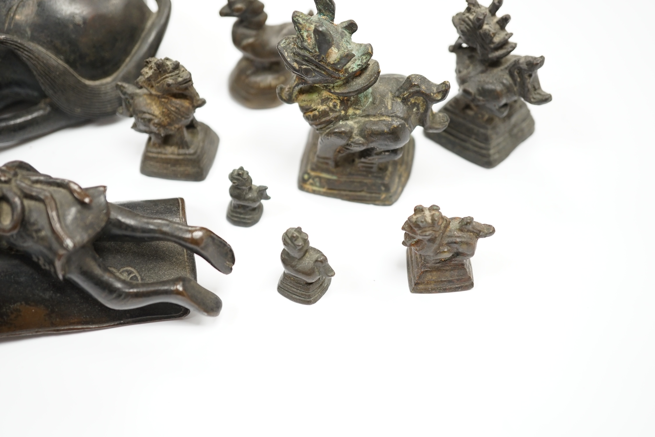 A Chinese bronze ‘water buffalo’ box and cover, Qing dynasty, and a set of Burmese opium weights, largest 18cm long